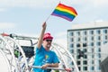 Man holding rainbow flag over his head during Stockholm Pride Parade